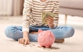 Teen girl with piggy bank and money at home Royalty Free Stock Photo