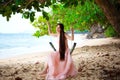 Teen girl in pink dress sitting on swing at beach Royalty Free Stock Photo