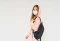 Teen girl in pink hoodie in face mask girl with backpack isolated on the white background