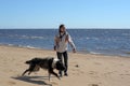 Teen girl playing with a dog in the sand Royalty Free Stock Photo