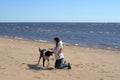 Teen girl playing with a dog in the sand Royalty Free Stock Photo