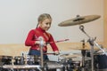 Teen girl playing the drums. Teen girls are having fun playing drum sets in music class. Girl in red drumming Royalty Free Stock Photo