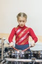 Teen girl playing the drums. Teen girls are having fun playing drum sets in music class. Girl in red drumming. vertical photo Royalty Free Stock Photo
