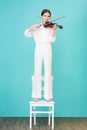 teen girl playing violin and standing on chair Royalty Free Stock Photo