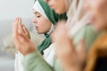 Teen girl praying near blurred women Royalty Free Stock Photo