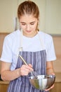 teen girl preparing food, cooking in kitchen, mixing ingredients in bowl