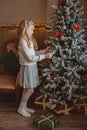 Teen girl with present near Christmas tree standing Royalty Free Stock Photo