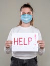 Teen girl in protective mask holding HELP sign