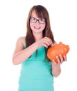 Teen girl putting coin into piggy bank Royalty Free Stock Photo