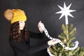 Teen girl putting white paper chain on Christmas tree