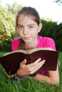 Teen girl reading the Bible outdoors Royalty Free Stock Photo