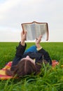 Teen girl reading the Bible outdoors