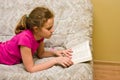 Teen girl reading a book on bed