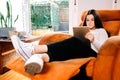 Teen girl reading on the tablet sitting on the sofa Royalty Free Stock Photo