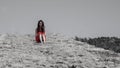 Teen girl in red dress sitting on ancient bridge