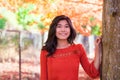 Teen girl in red shirt under red maple tree Royalty Free Stock Photo