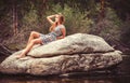 Teen girl relaxing on large rock Royalty Free Stock Photo