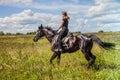 Beautiful redheaded girl riding a horse in countryside. . Royalty Free Stock Photo