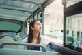 Girl rides a tourist bus and looks out the window.