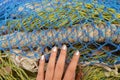 Teen girl`s hand touching colourful fishing nets Royalty Free Stock Photo