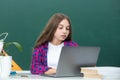 Teen girl school student with laptop at school. Teenager Student Working On Laptop in classroom. Little girl using Royalty Free Stock Photo