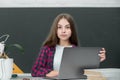 Teen girl school student with laptop at school. Teenager Student Working On Laptop in classroom. Little girl using Royalty Free Stock Photo