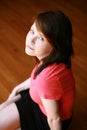 Teen girl seated on wood floor Royalty Free Stock Photo