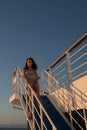 Teen girl in shorts standing on top of blue stairway on ferry boat Royalty Free Stock Photo