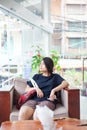 Teen girl sitting in hotel lobby looking out window, bored