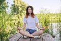 Teen girl sitting in lotus position, meditating on nature Royalty Free Stock Photo