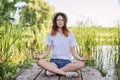 Teen girl sitting in lotus position, meditating on nature Royalty Free Stock Photo