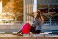 teen girl sitting on a skate Board with a pink backpack in the big city Royalty Free Stock Photo