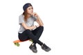 Teen girl sitting on skate board thinking looking to side Royalty Free Stock Photo