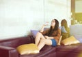 Teen girl sitting on sofa drinking bottled water Royalty Free Stock Photo