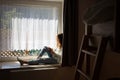 Teen girl sitting on a windowsill