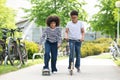 Teen girl on skateboard and boy on scooter having fun on sunny day, relaxation, sports lifestyle. Royalty Free Stock Photo