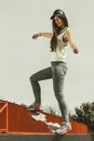 Teen girl skater riding skateboard on street. Royalty Free Stock Photo