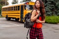 Teen Girl Standing Near Yellow School Bus Parked On The Street