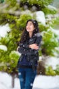 Teen girl standing outdoors in winter snowfall shivering from cold