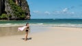 Teen girl standing on tropical beach with towel Royalty Free Stock Photo