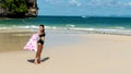 Teen girl standing on tropical beach with towel Royalty Free Stock Photo