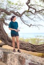 Teen girl standing on stone wall looking towards ocean Royalty Free Stock Photo