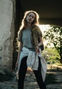 Teen girl stands in the arch at sunset. Silhouette of a girl with long hair Royalty Free Stock Photo