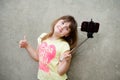 Teen girl stands with monopod in hands