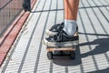 Teen girl stands on a skateboard. The photo shows a skate and black sneakers Royalty Free Stock Photo