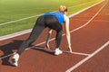 Teen Girl in the Starting Blocks at a Track Meet. Sports start. girl in pose on the starting line of treadmill. Active lifestyle. Royalty Free Stock Photo