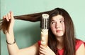 Teen girl straighten her long brown hair Royalty Free Stock Photo