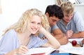 Teen girl studying in the library with her friends Royalty Free Stock Photo