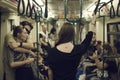 Teen girl in a subway seen from behind, with a tattoo on her neck