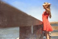 Teen girl in sundress looking out onto water